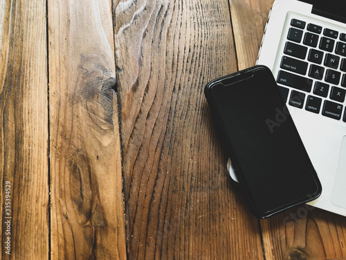 laptop on wooden table with a phone home desk