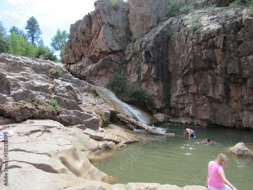 The Ellison Creek waterfall with tourists and locals sitting and swimming at the Water Wheel Falls hiking trail photo