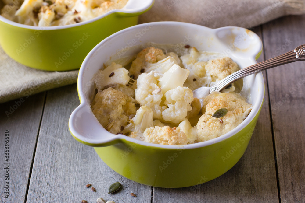 Baked cauliflower with cream on wooden table Baked cauliflower with cream on wooden table