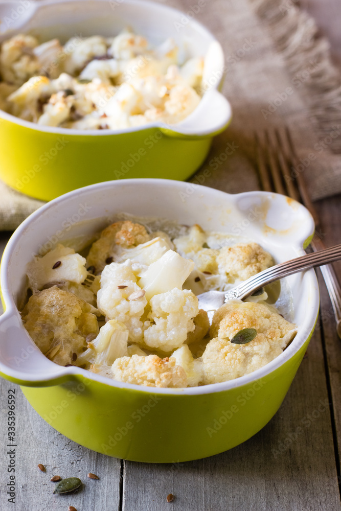 Baked cauliflower with cream on wooden table Baked cauliflower with cream on wooden table