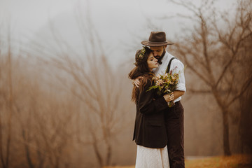 gorgeous bride and stylish groom, boho wedding couple, luxury ceremony at mountains with amazing view, space for text