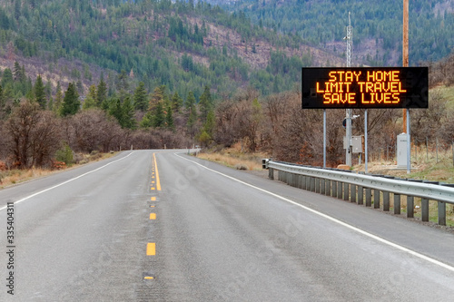Electronic sign along U.S. Highway 97 in Washington state notifying people to stay home, limit travel and save lives by reducing the risk of being infected due to COVID-19 photo