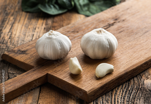 Garlic on chopping board on wooden background. photo