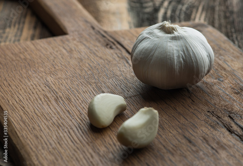 Garlic on chopping board on wooden background..