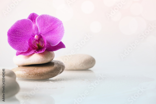 Wellness, relax, massage and wellbeing concept. Spa stones and orchid flower over white background.