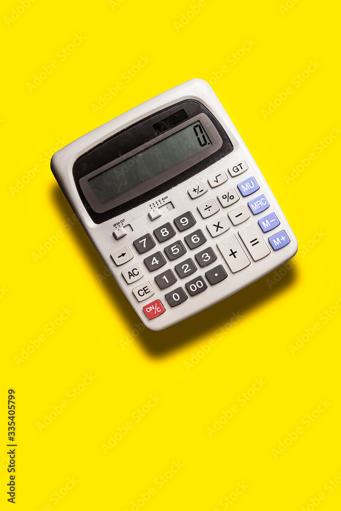 fly grey big calculator on yellow background fly grey big calculator on yellow background