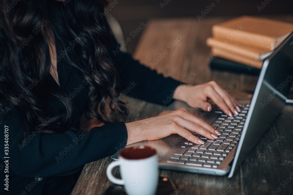 Fototapeta premium Close up of female hands while typing on laptop