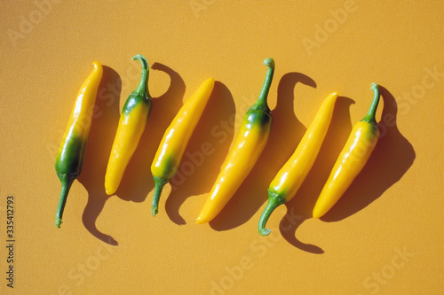 Yellow hot peppers on yellow background. Food photography photo