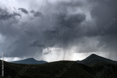 Amazing flowing rainy clouds in evening mountains. Beautiful nature of Carpathians. Landscape photography
