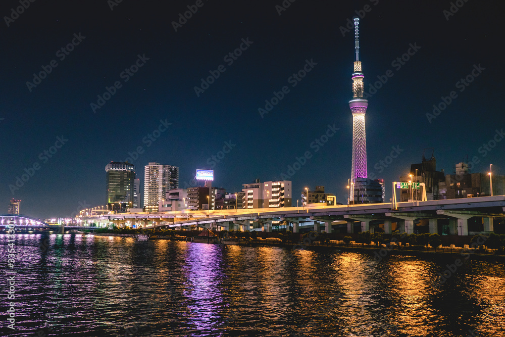 Obraz premium Pejzaż Tokio nocą, z rzeką Sumida z odbiciami z przodu i wieżą Tokyo Skytree ze światłami w tle