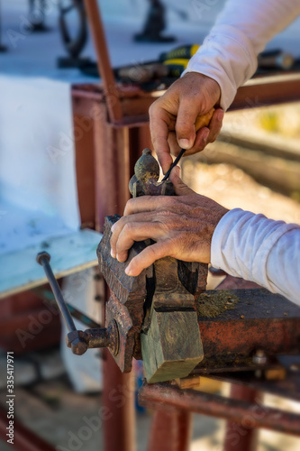 Wood carving. Manufacture of a statue in a manual way. Close-up. Selective focus.