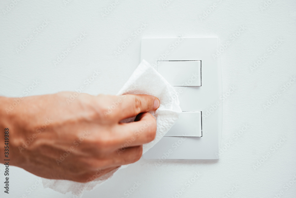 Cleaning light switch to prevent coronavirus contamination. Precaution against Covid-19 Cleaning light switch to prevent coronavirus contamination. Precaution against Covid-19