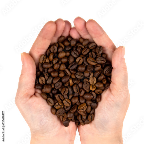 Roasted coffee beans in the palms top view isolated on a white background