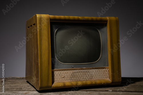 Image of an old brown wooden television, side view isolated on grey background.
