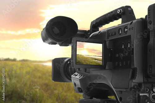 Recording beautiful sunset on professional video camera