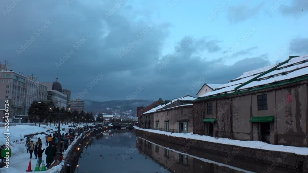 OTARU, HOKKAIDO, JAPAN - FEBRUARY 2020 : Scenery of OTARU CANAL in winter snow season. Popular tourist destination for Japanese and foreign visitors. Time lapse shot sunset to night. OTARU, HOKKAIDO, JAPAN - FEBRUARY 2020 : Scenery of OTARU CANAL in winter snow season. Popular tourist destination for Japanese and foreign visitors. Time lapse shot sunset to night.