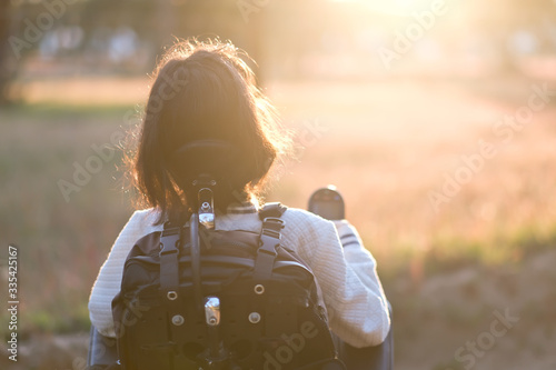 A disabled woman standing outside looking at the sunset reflecting