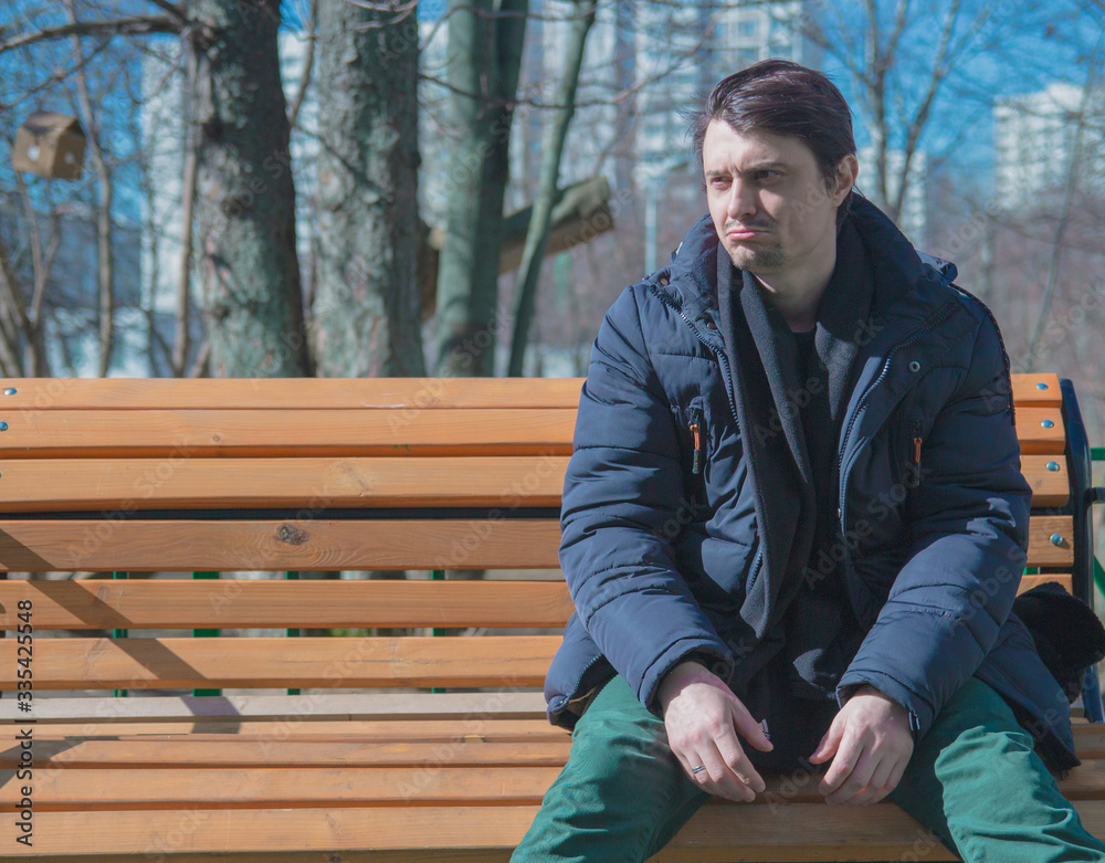 Fototapeta premium Depressive guy sitting on park benches.