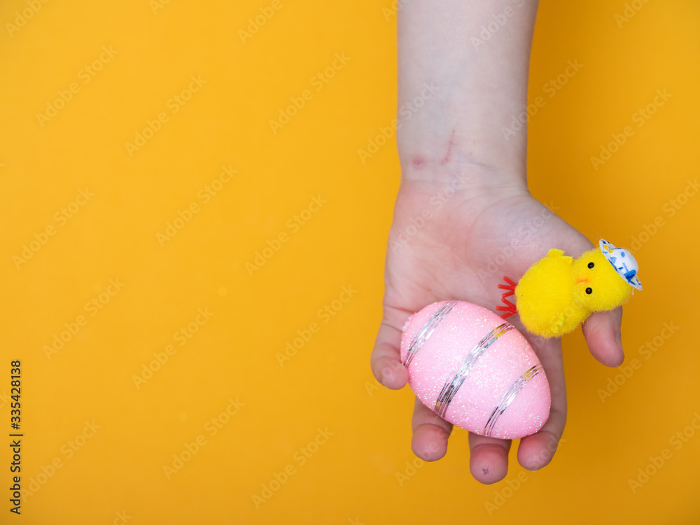 Fototapeta premium baby hand close up holding Easter eggs. Easter card