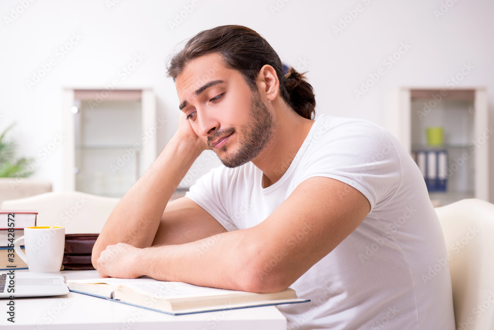 Young male student preparing for exams at home