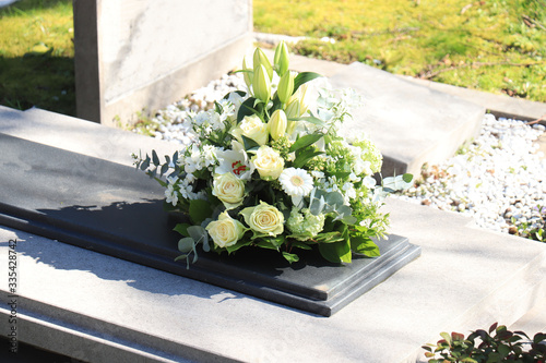 Fototapeta Funeral flowers on a tomb