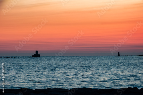 A barrier breakwater wall at the entrance to a port at sunset-sunrise photo