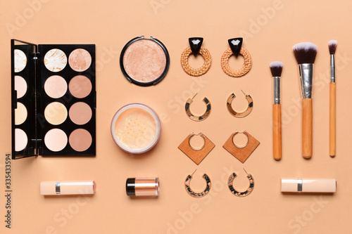 Makeup cosmetics with accessories on color background