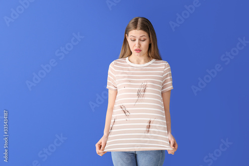 Troubled woman in dirty clothes on color background