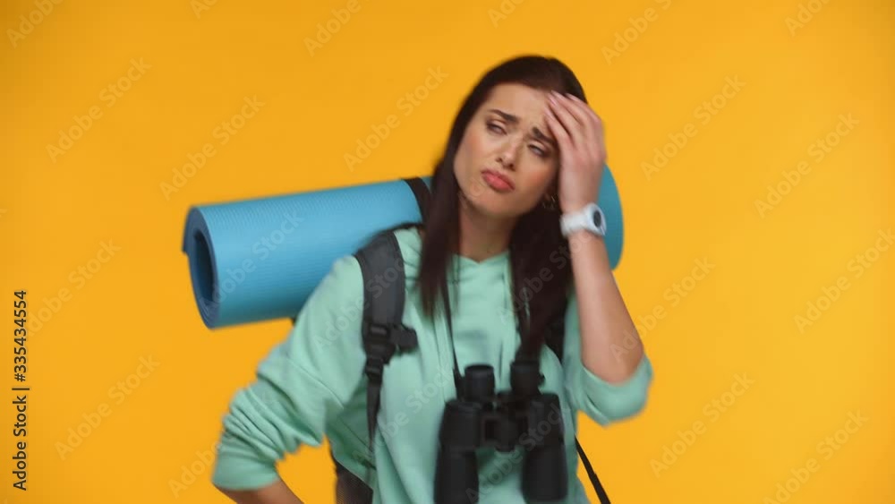 Sad traveler showing stop gesture at camera isolated on yellow Sad traveler showing stop gesture at camera isolated on yellow