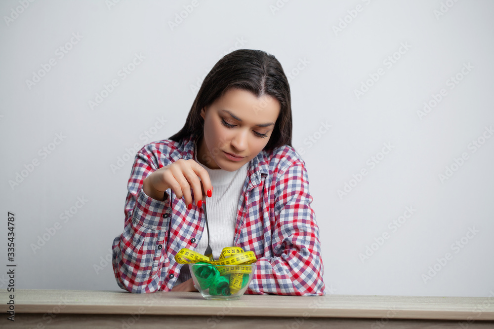 Concept of growing thin woman with plate full of tape measure. Concept of growing thin woman with plate full of tape measure.