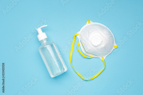 Sanitizer and medical mask on color background