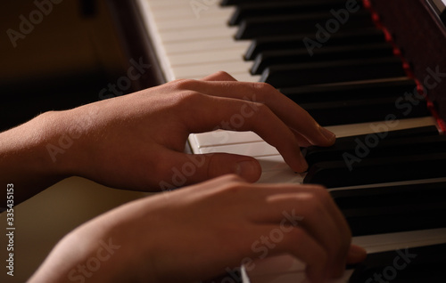 close up teen's hand playing piano