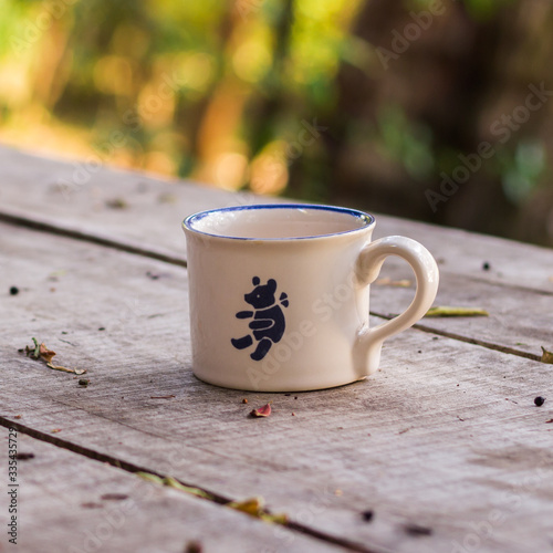 Nice coffee cup in a wooden table with nature background