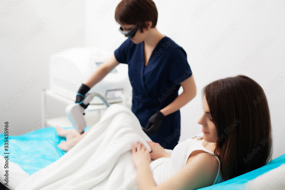 Beautiful woman in beauty studio getting laser hair removal procedure Beautiful woman in beauty studio getting laser hair removal procedure
