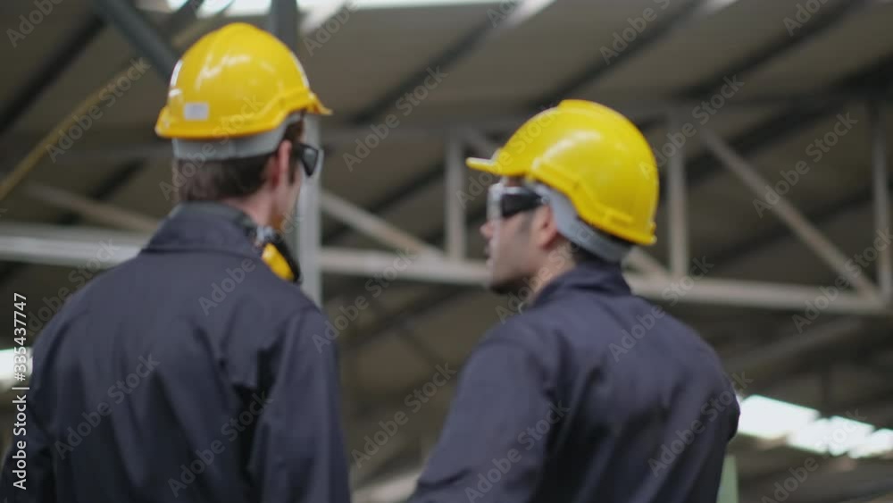 Soft blur scene of the back of two technician men or factory workers stand and look to various type of machine in factory. Soft blur scene of the back of two technician men or factory workers stand and look to various type of machine in factory.
