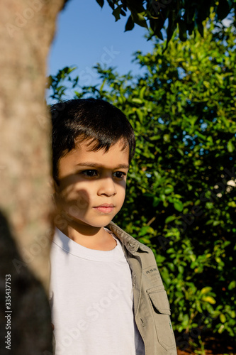 boy standing in the shade enjoying the sun on his face