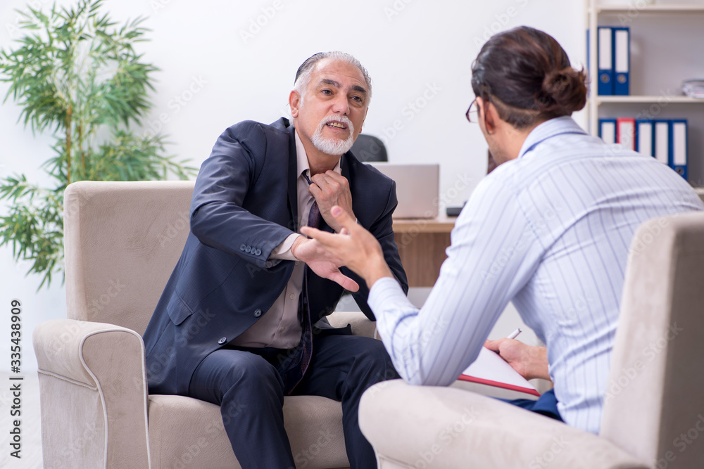 Old man visiting young male doctor psychologist - obrazy, fototapety, plakaty 
