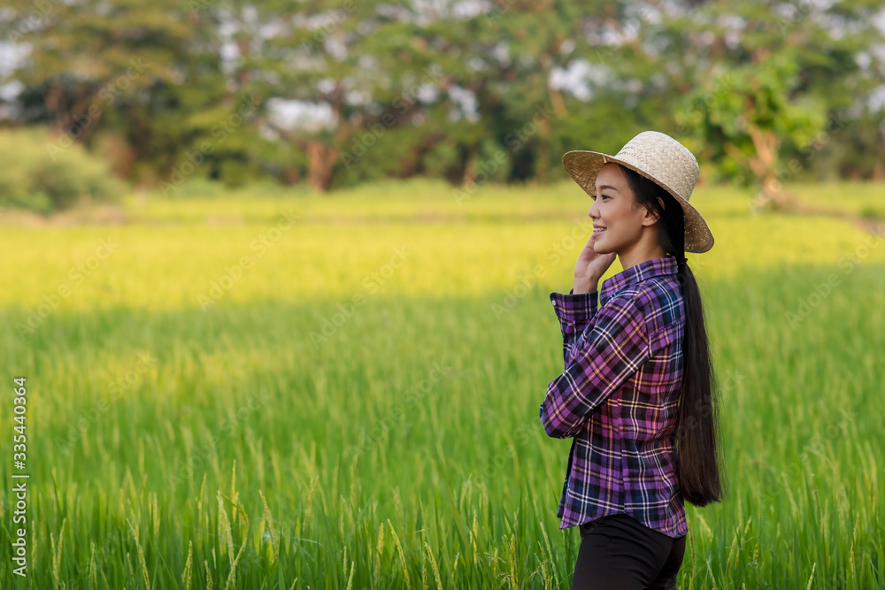 portrait of woman modern farmer in rice field agricultural production. and golden rice field background