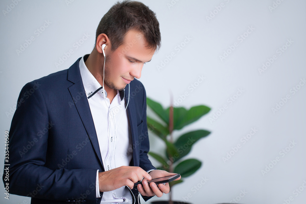 Handsome young worker uses a telephone in the company office Handsome young worker uses a telephone in the company office