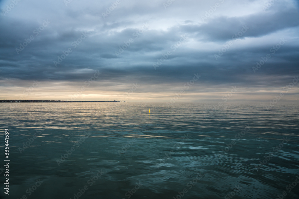 Obraz premium Panoramic View of Ocean with Dark Clouds Covering Sunset with clear water