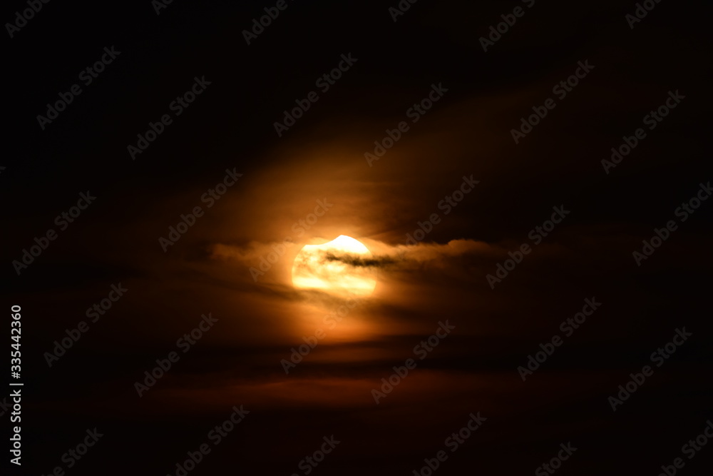 partial solar eclipse with clouds, seen over Buenos Aires February 15, 2018