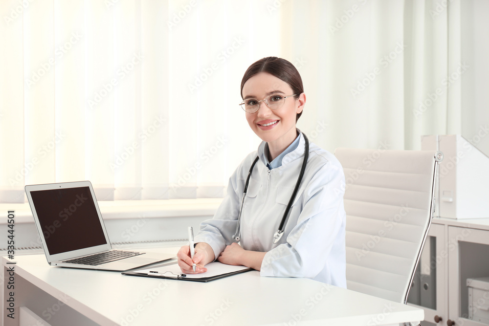 Portrait of young female doctor in white coat at workplace Portrait of young female doctor in white coat at workplace