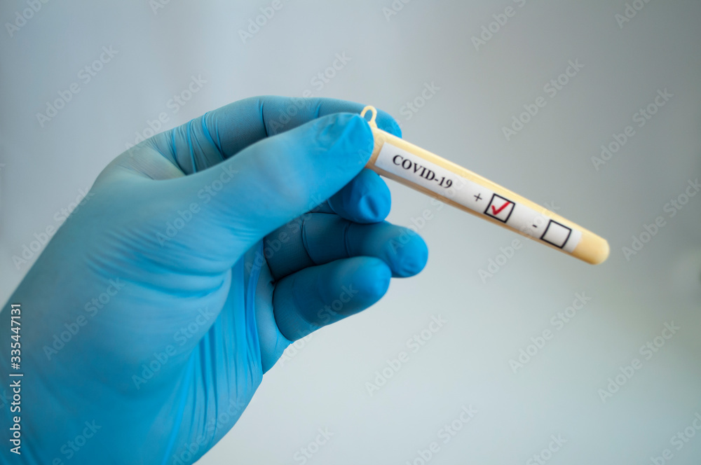 Naklejka premium Test tube with coronavirus tests in the hand of a medical professional