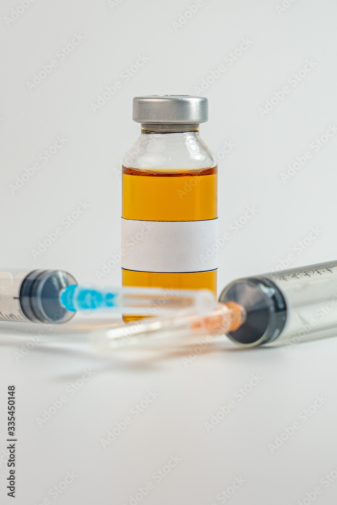 Studio shot of vaccine bottle with blank label and syringe injection Studio shot of vaccine bottle with blank label and syringe injection