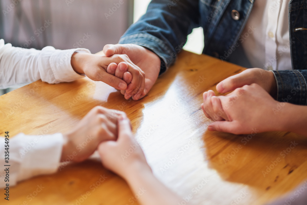 Group of people sitting in a circle holding hands and pray together or in therapy session Group of people sitting in a circle holding hands and pray together or in therapy session