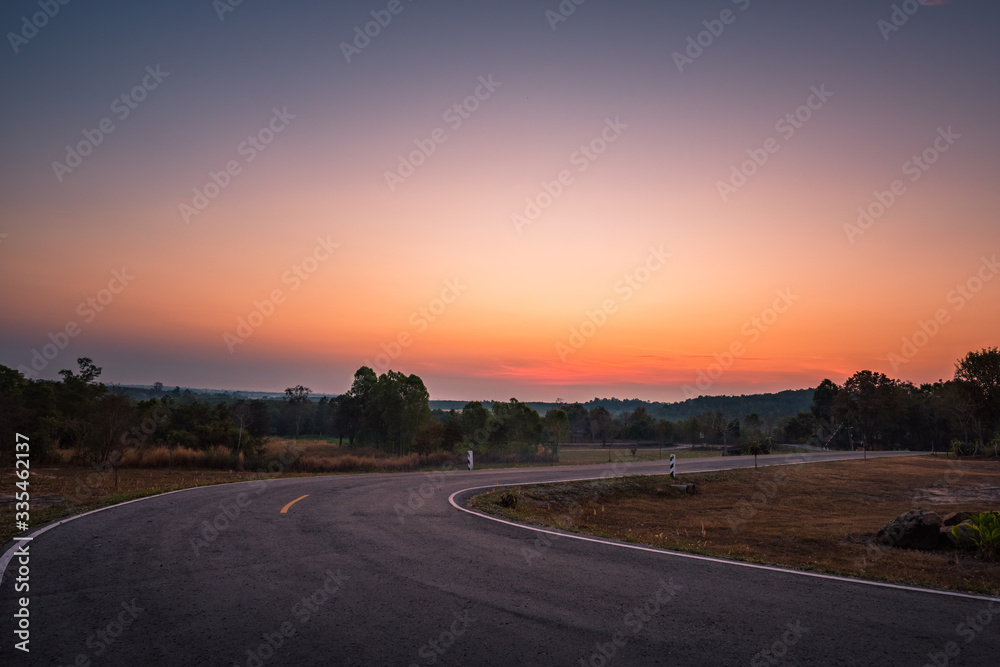 The sun rises with road in the fall