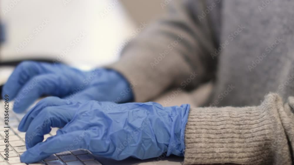 Woman Typing On Computer With Rubber Gloves On Woman Typing On Computer With Rubber Gloves On
