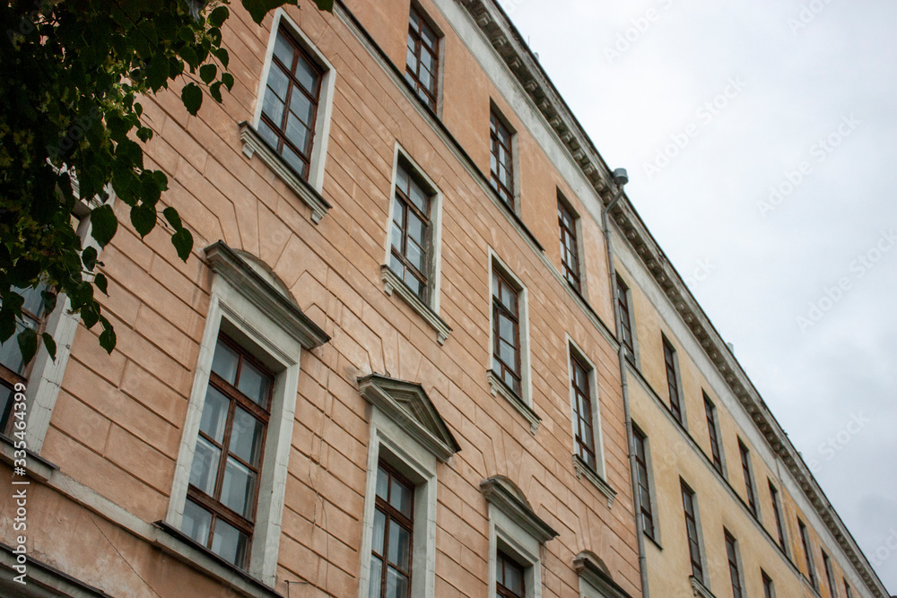 View of the facade of a multi-storey residential building in Ryazan, covered with a network of windows. View from below to the wall of the house.