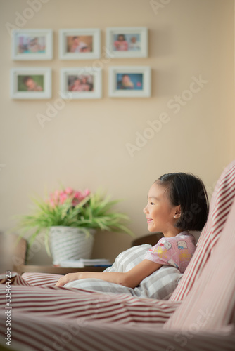 Asian child (girl) at home during lockdown, watching TV