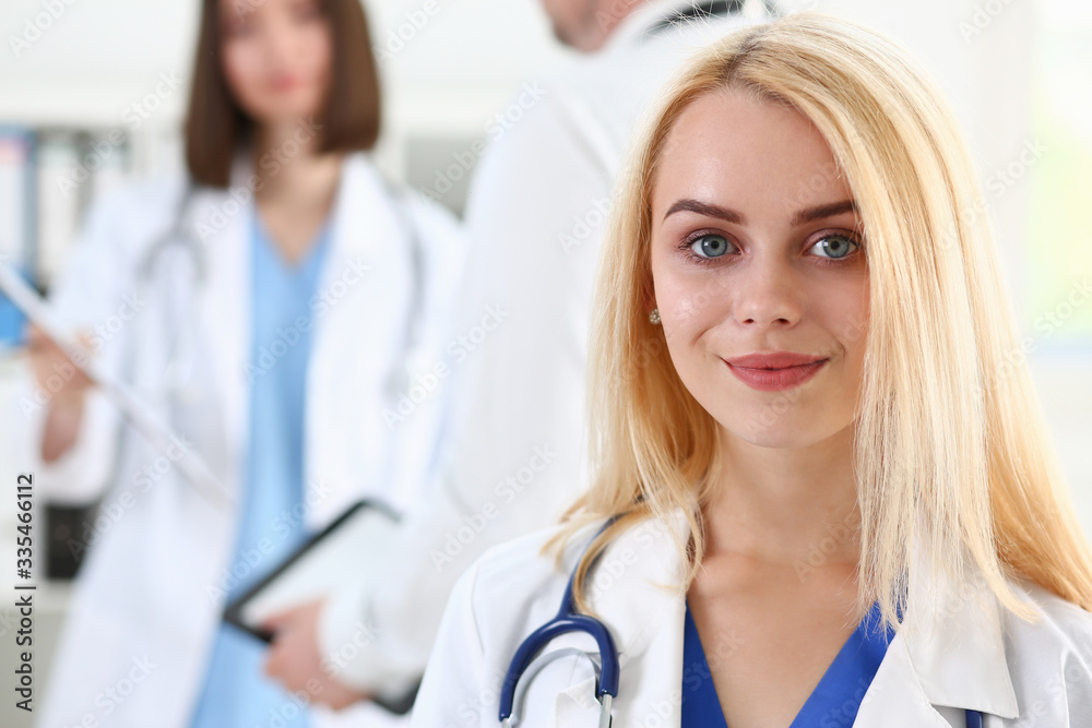 Beautiful smiling female doctor stand in office portrait. Physical and patient disease prevention, exam, er, ward round, 911, prescribe remedy, healthy lifestyle, consultant, nurse profession concept Beautiful smiling female doctor stand in office portrait. Physical and patient disease prevention, exam, er, ward round, 911, prescribe remedy, healthy lifestyle, consultant, nurse profession concept